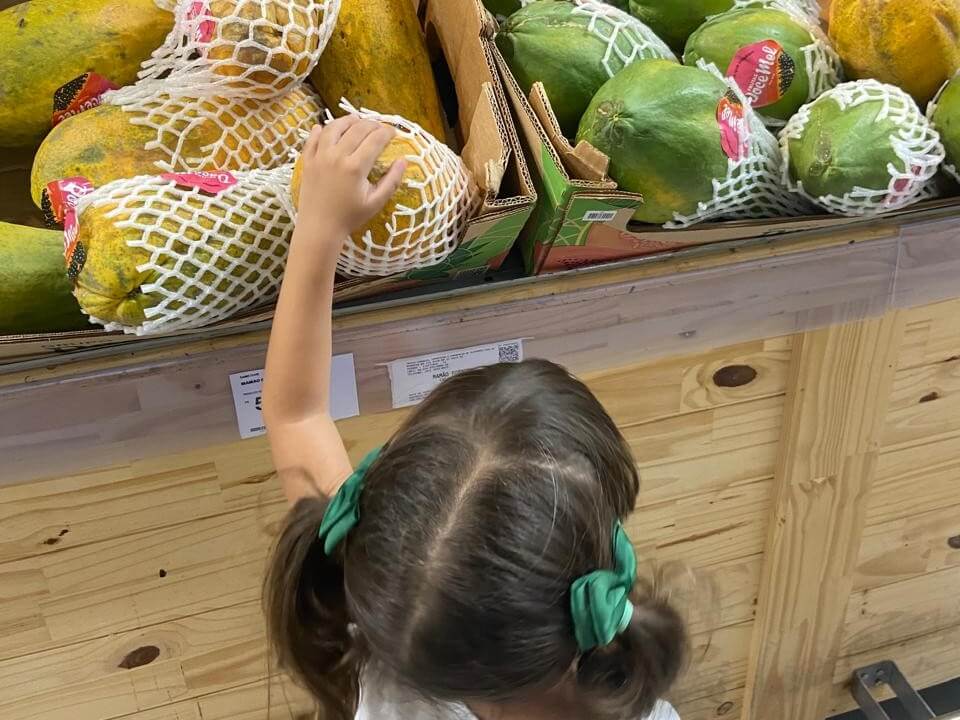 Criança explorando frutas em família